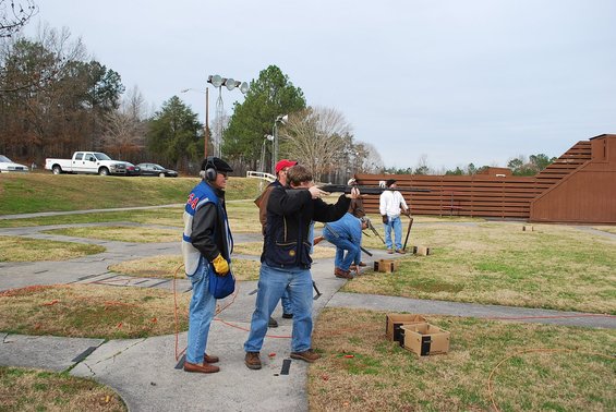White pickup truck parked on a grassy embankment at a shooting range