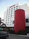 1991 Ford Bronco - Marriott hotel exterior a distinctive red cylindrical architectural element and a parked car.