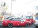 1991 Ford Bronco - A red taxi sedan with white-wall tires is seen in traffic next to other vehicles.