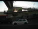 1991 Ford Bronco - Two vehicles pass by an elevated pedestrian walkway under a bright sky.