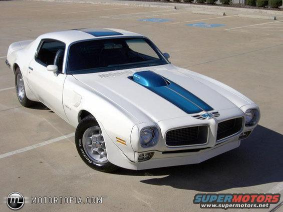 White 1970s Pontiac Firebird coupe with blue hood scoop and racing stripes, parked outdoors