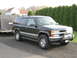 1998 Chevrolet Tahoe - Black 1998 Chevrolet Tahoe with a trailer attached is parked on a gravel driveway.