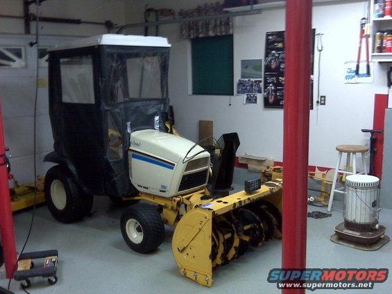 Cub Cadet garden tractor with snow blower attachment and cab in a garage