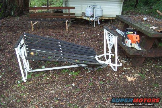Chainsaw on picnic table next to broken bench and propane tanks