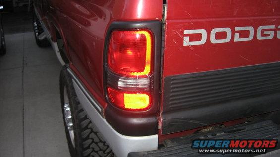 Red Dodge pickup truck rear quarter panel with taillight and tailgate visible