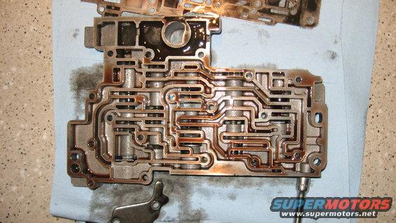 Transmission valve body with many internal passages, some filled with dark fluid