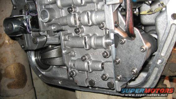 Close-up of a transmission valve body with visible solenoids and metal casing