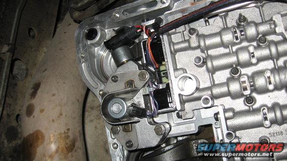 close-up of an automatic transmission valve body with wiring and solenoids