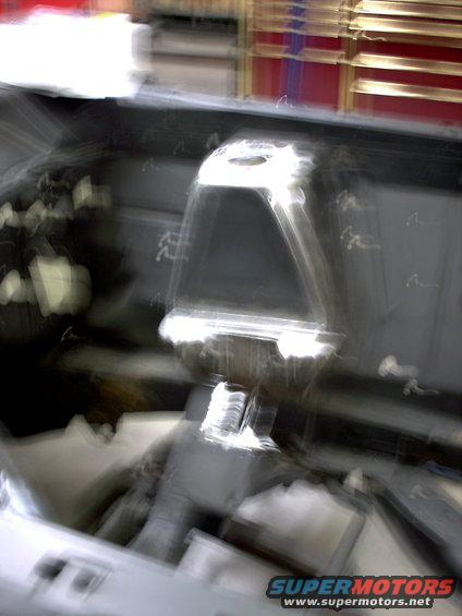Blurry interior view of a car dashboard with a central console and instrument cluster area