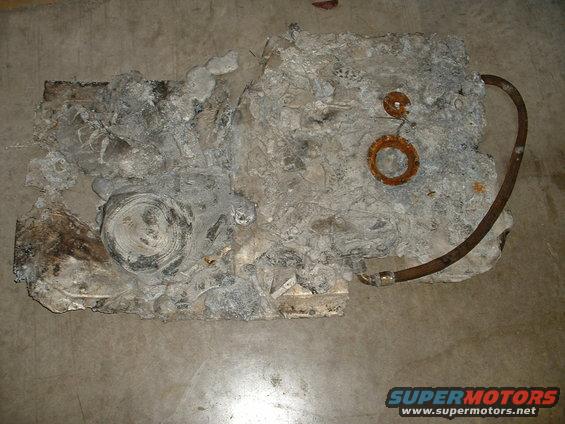 Damaged engine block with rusty hose attached