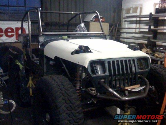 1994 Jeep YJ front view, undergoing custom build with roll cage and large tires