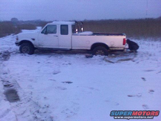 White pickup truck stuck in snow, driver side visible