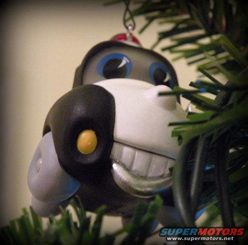 Dog ornament with blue eyes and big teeth on a Christmas tree