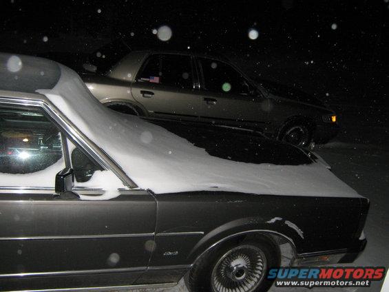 Gold 2000 Mercury Grand Marquis in snow, 3q front view