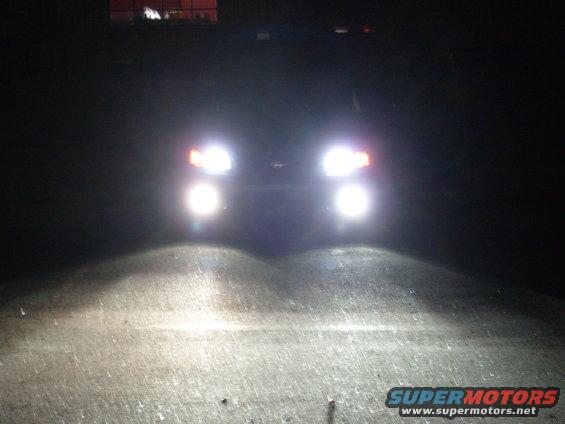 vehicle headlights on at night, illuminating the road ahead