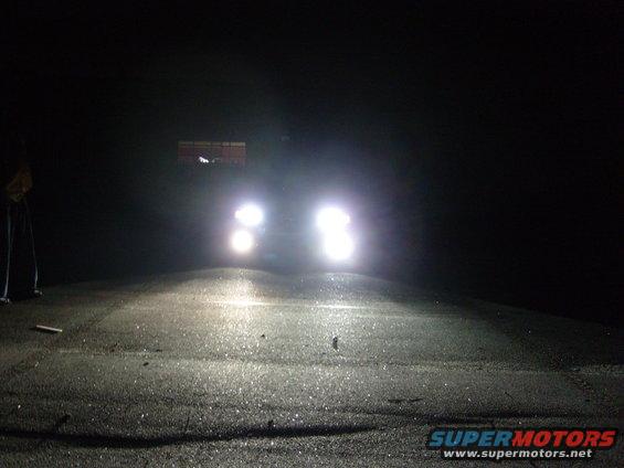 Headlights of a vehicle at night on a wet road