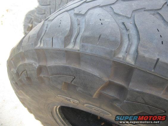 Tire tread with large, aggressive blocks and sipes, showing some wear