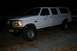 1992 Ford C-350 (Centurion Conversions) - This modified SUV is parked outdoors at night, showing off its lifted suspension and off-road tires.