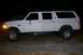 1992 Ford C-350 (Centurion Conversions) - This white extended cab pickup truck has a custom rear body, giving it an SUV-like appearance, and is lifted with 4x4 badging.