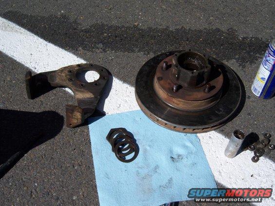 28may09002.jpg The brakecaliper bracket, rotor, and hub. You can also see on the shop towel the axle nuts and washers that go inside the manual locking hub.