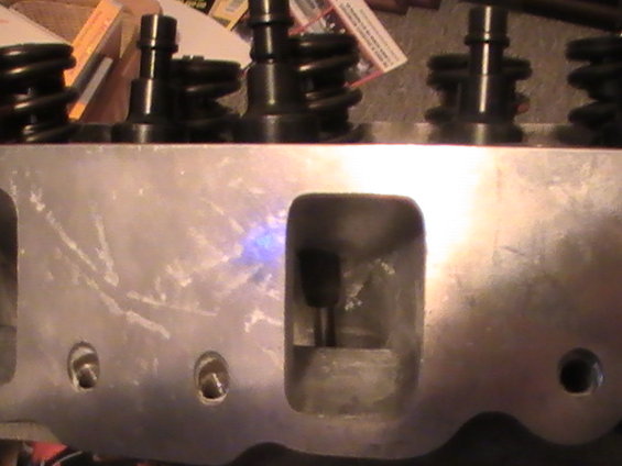 Aluminum engine cylinder head with black valve springs and pushrods visible