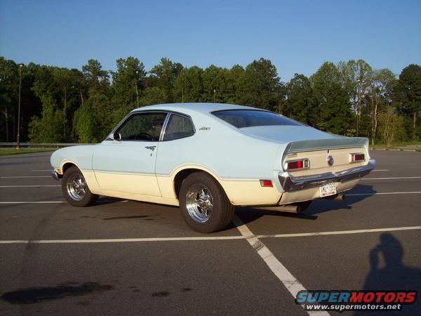 1973 Ford Maverick coupe, two-tone blue and cream paint, chrome wheels, parked in lot