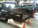 1996 Ford Bronco - Two Ford Broncos are in a garage, one is on jack stands and appears to be undergoing repairs.
