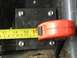 1996 Ford Bronco - A measuring tape is used to measure a metal plate that has been bolted to a surface.