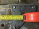 1996 Ford Bronco - A measuring tape is used to measure a metal plate, likely for a custom build or repair.