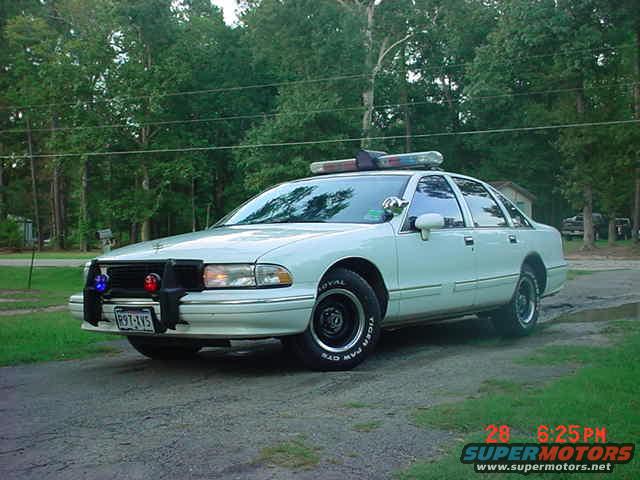 White 2003 Ford Crown Victoria police car with a push bumper and light bar