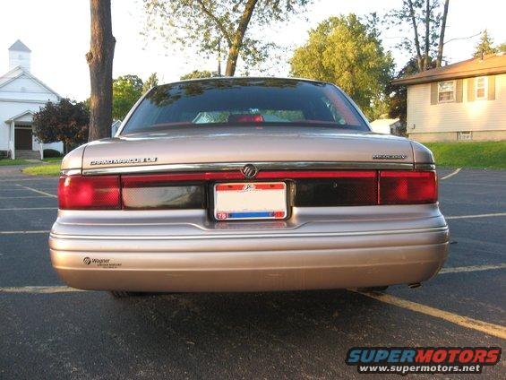 Rear view of a 1995 Mercury Grand Marquis, beige, with a license plate and a Wagner sticker