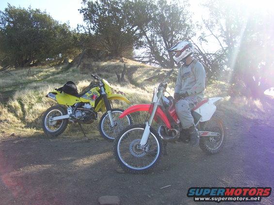 Red dirt bike with rider in foreground, yellow dirt bike behind