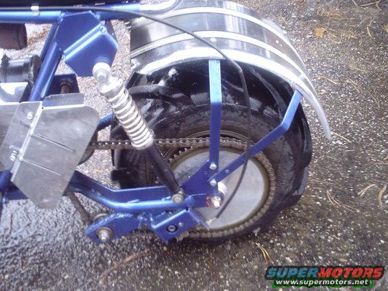 Blue motorcycle frame with rear wheel, chain, and shock absorber visible