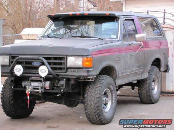 Gray Ford Bronco with purple stripe, lifted suspension, winch, and off-road tires