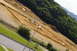 1986 Ford Bronco - RC car track on a dirt hillside with surrounding vegetation and a street in the foreground.