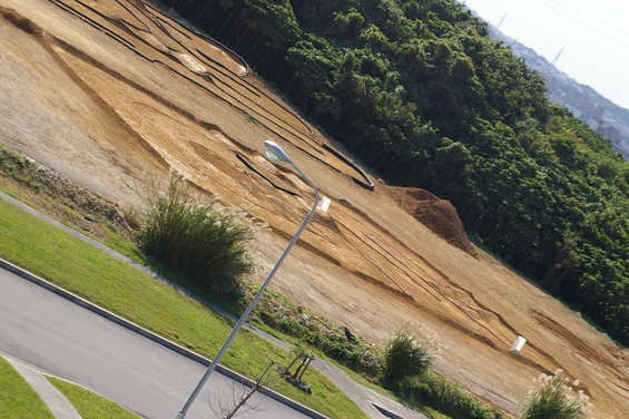 dirt track on a hillside with trees in background