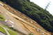 1986 Ford Bronco - A dirt RC track is laid out on a grassy and wooded hillside under a bright sky.