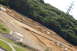 1986 Ford Bronco - A remote-controlled car track is laid out on a steep, wooded hillside, with a power line tower visible in the distance.