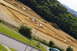 1986 Ford Bronco - A dirt track for remote-controlled cars is visible on a sloped hill, bordered by greenery and a road.