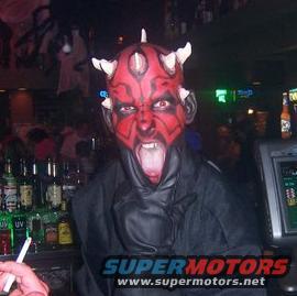 Person in Darth Maul costume with face paint and horns, standing in front of a bar