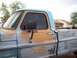 1971 Ford F-100 - This weathered pickup truck shows significant rust and paint wear, with a two-tone blue and tan exterior.