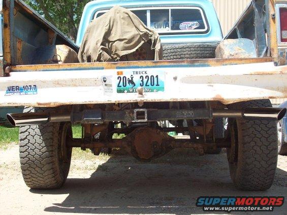 1971 Ford F-100 rear view, blue cab, white tailgate, chrome exhaust pipes, Wyoming license plate