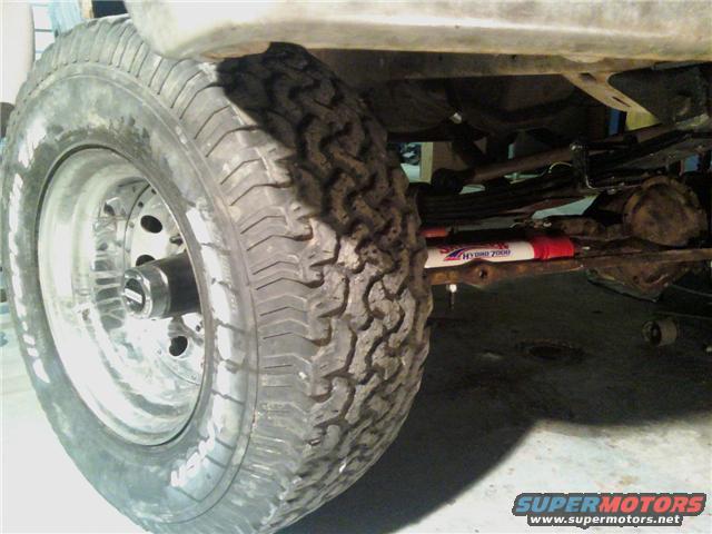 Close-up of a truck's front wheel, suspension, and shock absorber. Text on shock reads 'HYDRO 2000'