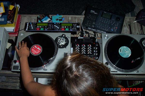 DJ setup with turntables, mixer, and Yamaha sampler