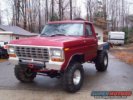 Red 1978 Ford F-150 with large tires and flatbed