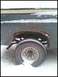 1996 Ford Bronco - A close-up view of a damaged and rusted rear wheel well on a Ford Bronco, partially covered in snow.