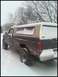 1996 Ford Bronco - A pickup truck with a camper shell is parked in a snowy outdoor setting.
