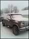 1996 Ford Bronco - A dark-colored Ford truck is parked outside in a snowy environment, with snow covering its body and the surrounding area.