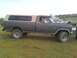 1996 Ford Bronco - This dark gray Ford F-250 pickup truck is equipped with a two-tone camper shell and is seen from the side.