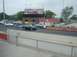 1999 Ford Taurus - Two sedans race on a track at Norwalk Raceway Park, with spectators in the grandstands.